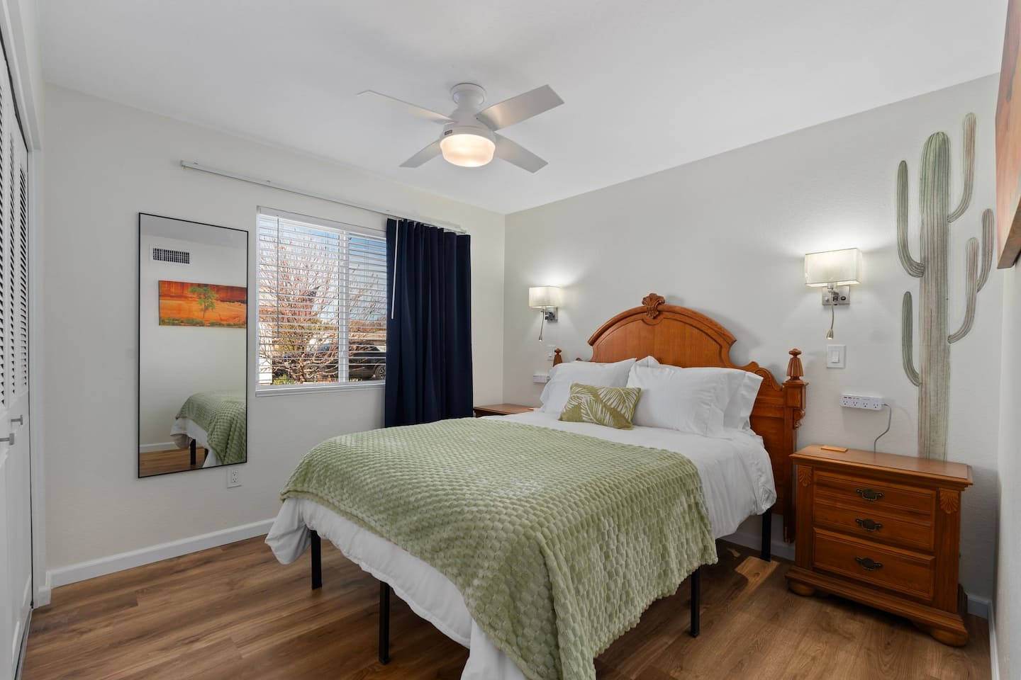Bedroom 3 at South Mountain Lagoon: a queen bed with a sage throw, navy curtains and a painted saguaro on the wall