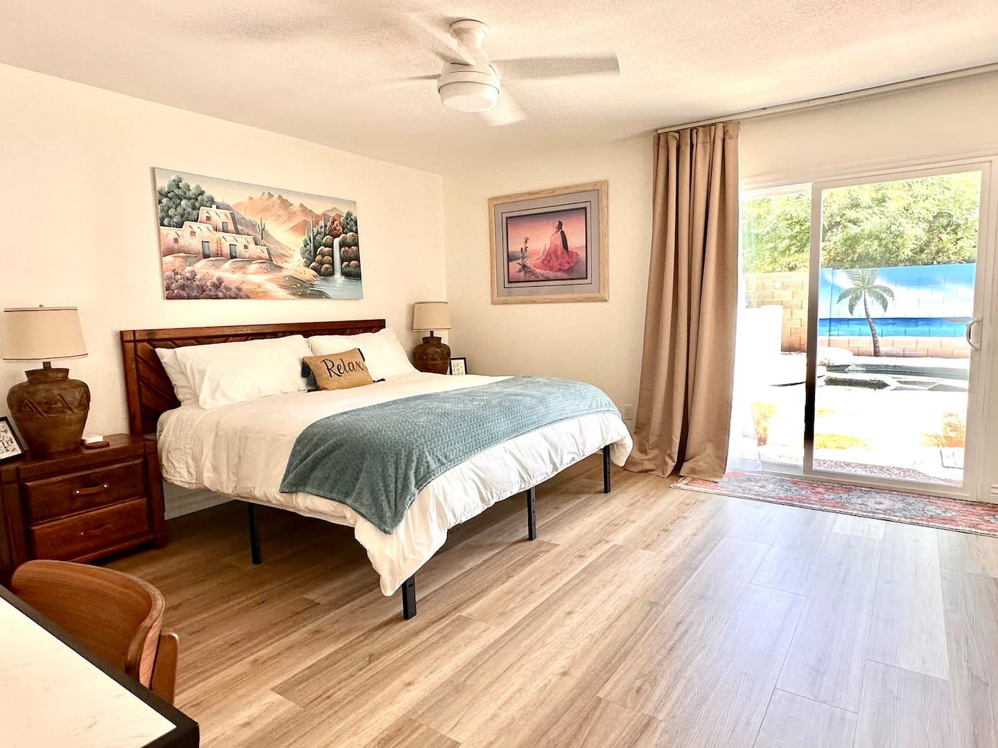 Bedroom 1 at South Mountain Oasis: a king bed with a teal throw and sliding doors opening to the pool