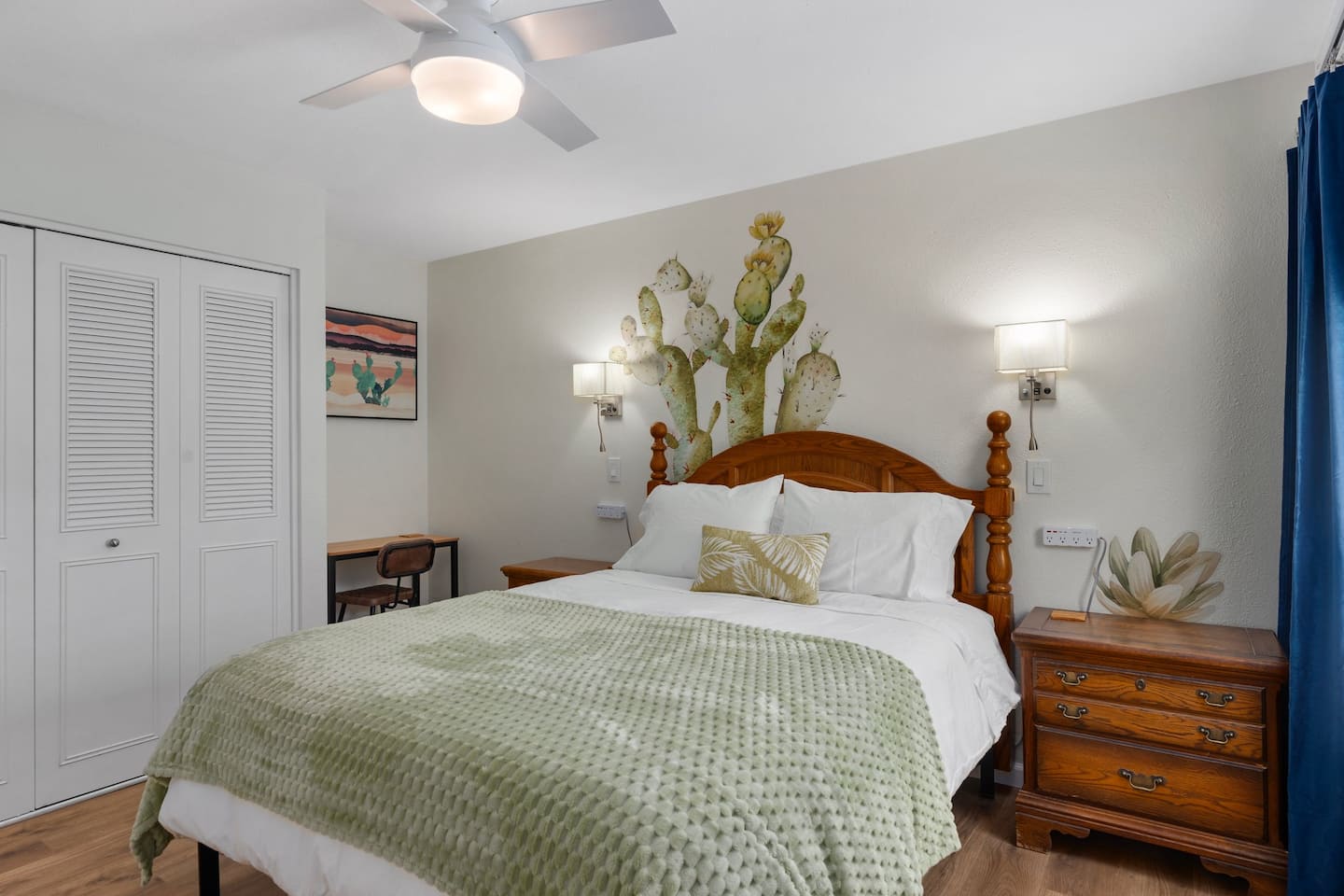 Bedroom 2 at South Mountain Lagoon: a queen bed with a sage throw beneath a painted prickly-pear mural